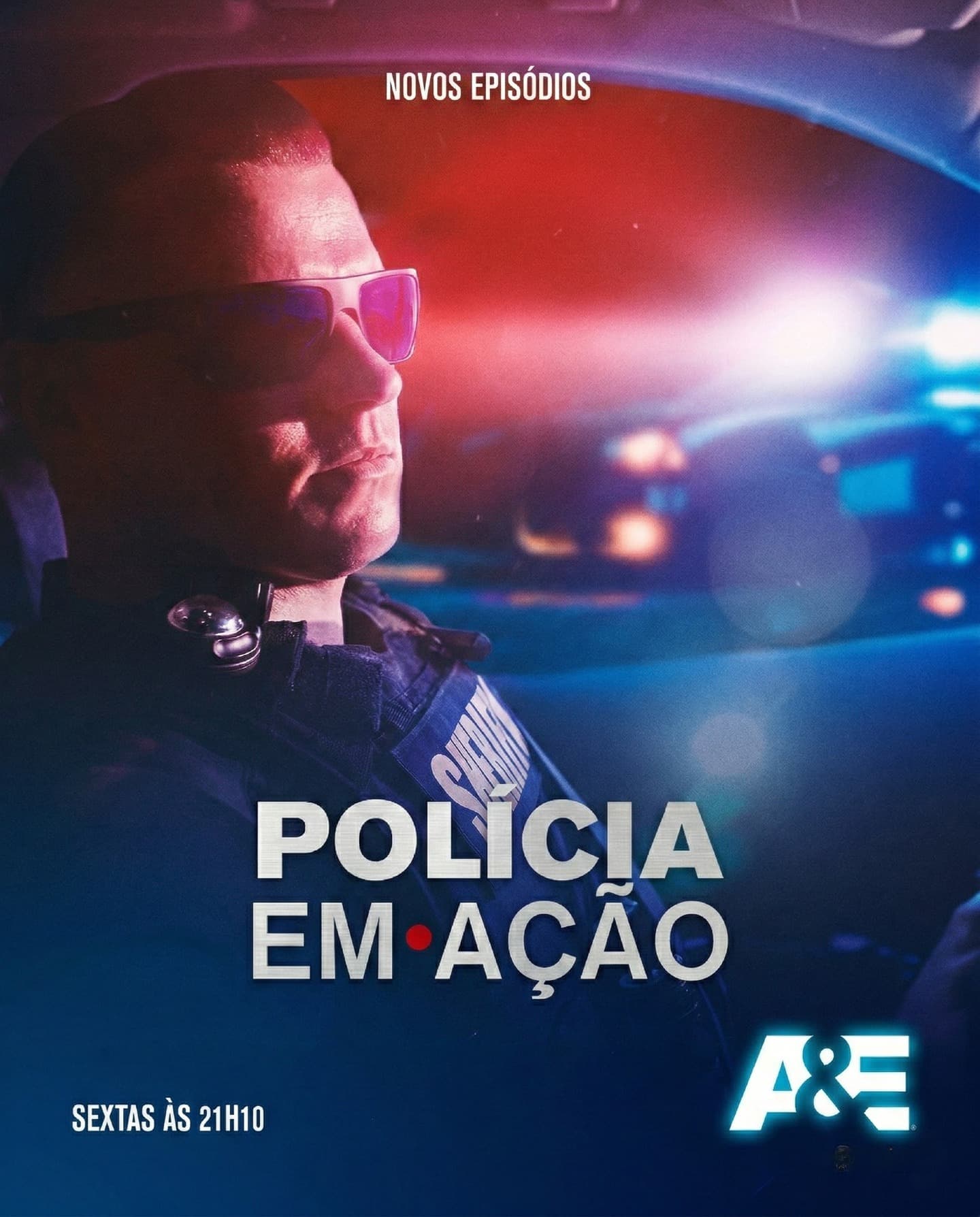 Policial fardado de óculos escuros sob luzes de emergência no programa Polícia em Ação.