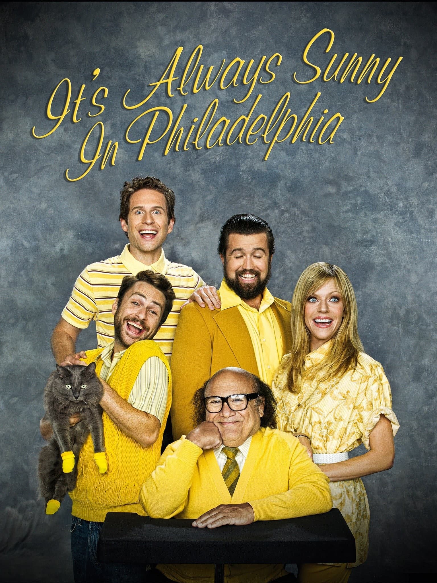 Elenco de It's Always Sunny in Philadelphia em roupas amarelas e gato com luvas.